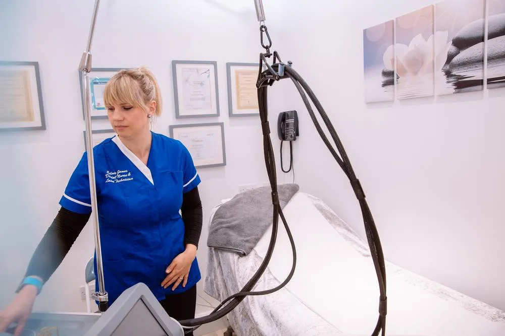 Beauty therapist standing beside the laser in the treatment room